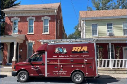 Mr Rooking service truck on call in front of house.